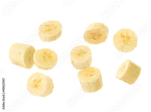 Slices of tasty ripe banana falling on white background