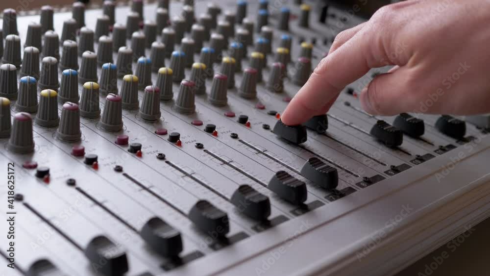 Sound Engineer, DJ Moves Sliders with Fingers on Audio Mixer in Recording Studio Sound Engineer, DJ Moves Sliders with Fingers on Audio Mixer in Recording Studio