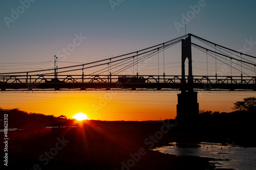 A nice sunset over a brige made of steel photo