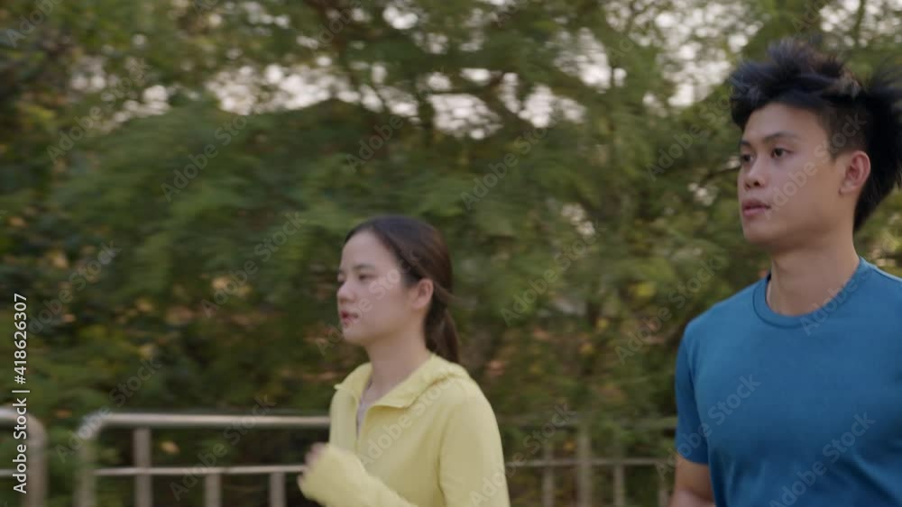 Couple of Asian is exercising outdoor running on the bridge in the city. Concept healthy running and outdoor workout Couple of Asian is exercising outdoor running on the bridge in the city. Concept healthy running and outdoor workout