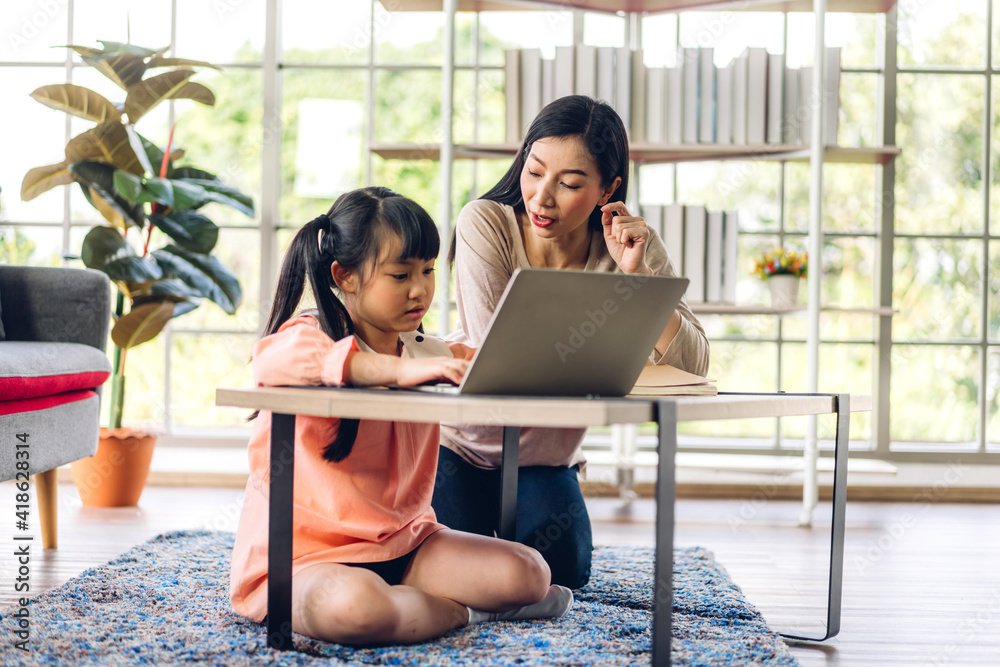 Mother and asian kid little girl learning and looking at laptop ...