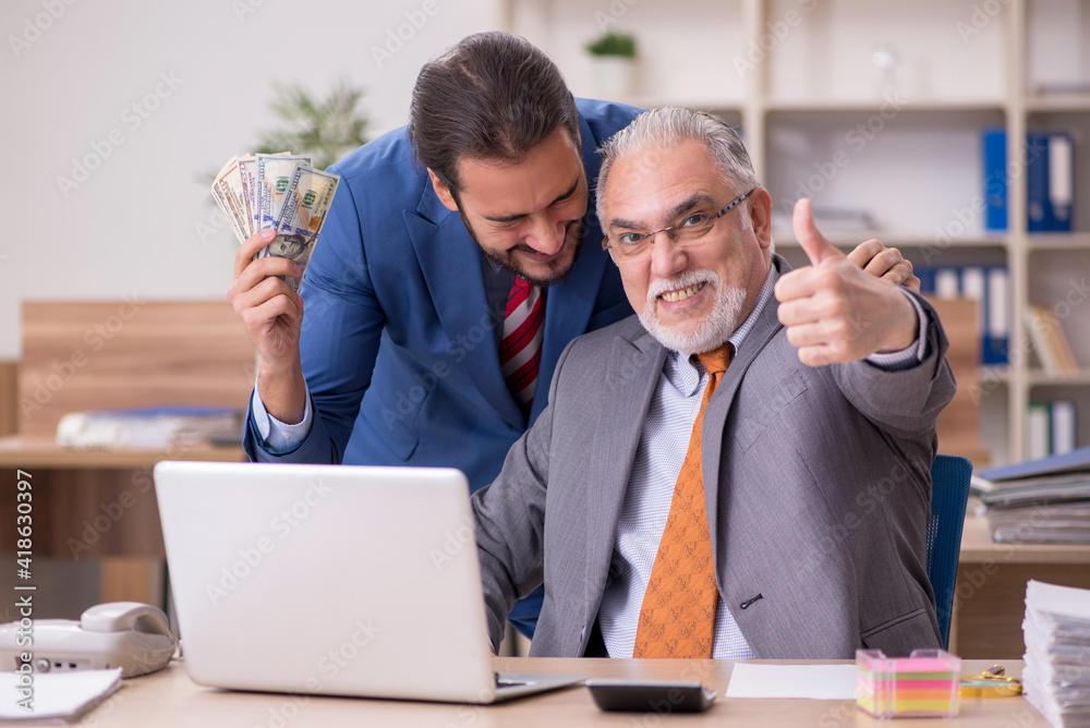Old male boss and young male employee in remuneration concept Old male boss and young male employee in remuneration concept