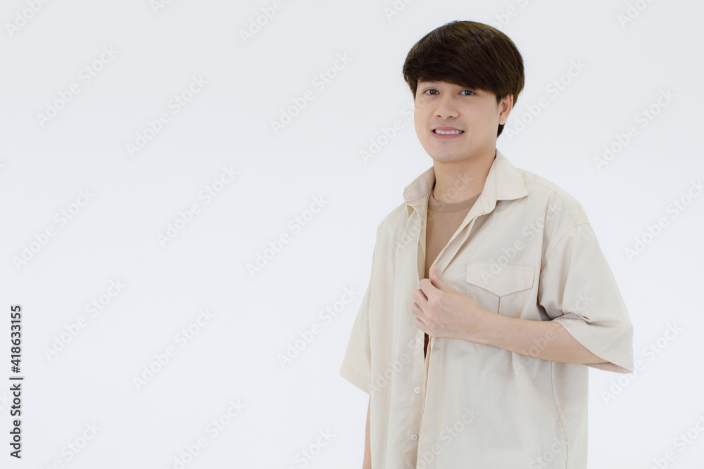 portrait of a good looking and confident young Asian man with stylish hairdressing wearing a casual white shirt over a light brown T-shirt smile and looking at a camera isolated on white background portrait of a good looking and confident young Asian man with stylish hairdressing wearing a casual white shirt over a light brown T-shirt smile and looking at a camera isolated on white background