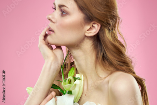 White flowers in female hands on a pink background portrait cropped view of model makeup