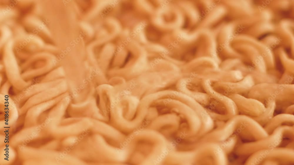 Quick cooking Chinese noodles close-up.Hot water is poured onto dry spaghetti.Cooking homemade quick pasta soup.Fast pasta food. Selective focus, shallow depth of field.