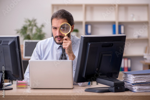 Young male employee in multitasking concept