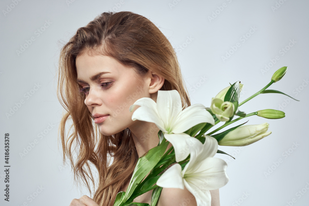Charming lady with white flowers portrait close-up light background