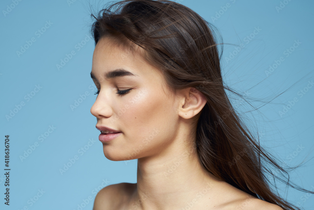 pretty brunette naked shoulders long hair skin care blue background pretty brunette naked shoulders long hair skin care blue background