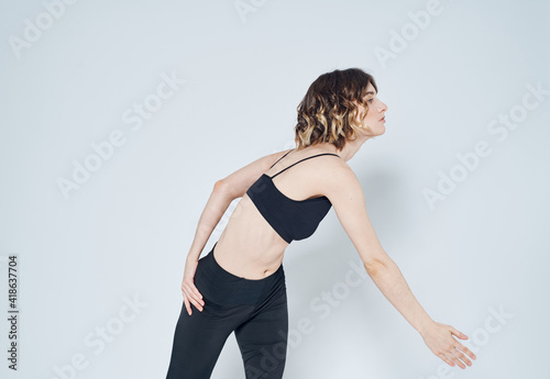 Woman in leggings doing exercises on a light background cropped view of fitness gymnastics