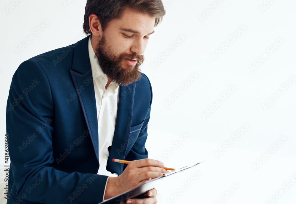 A man in a jacket and shirt with documents on his knees A man in a jacket and shirt with documents on his knees