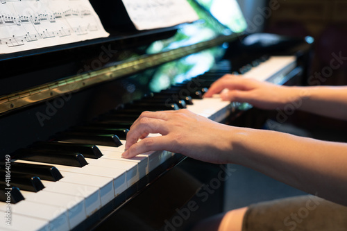 close up hand of young woman playing piano at home