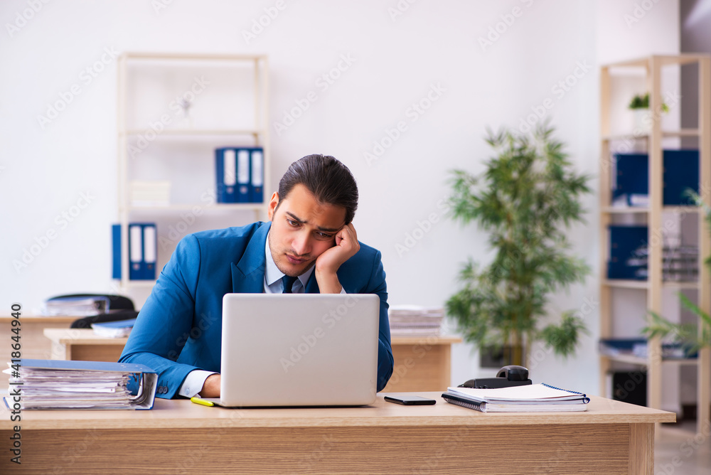 Young businessman employee unhappy with excessive work in the of Young businessman employee unhappy with excessive work in the of