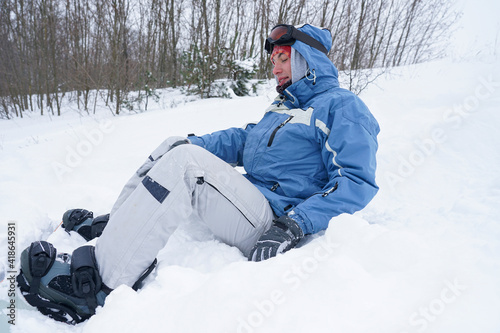 The guy on the snowboard fell into the snow