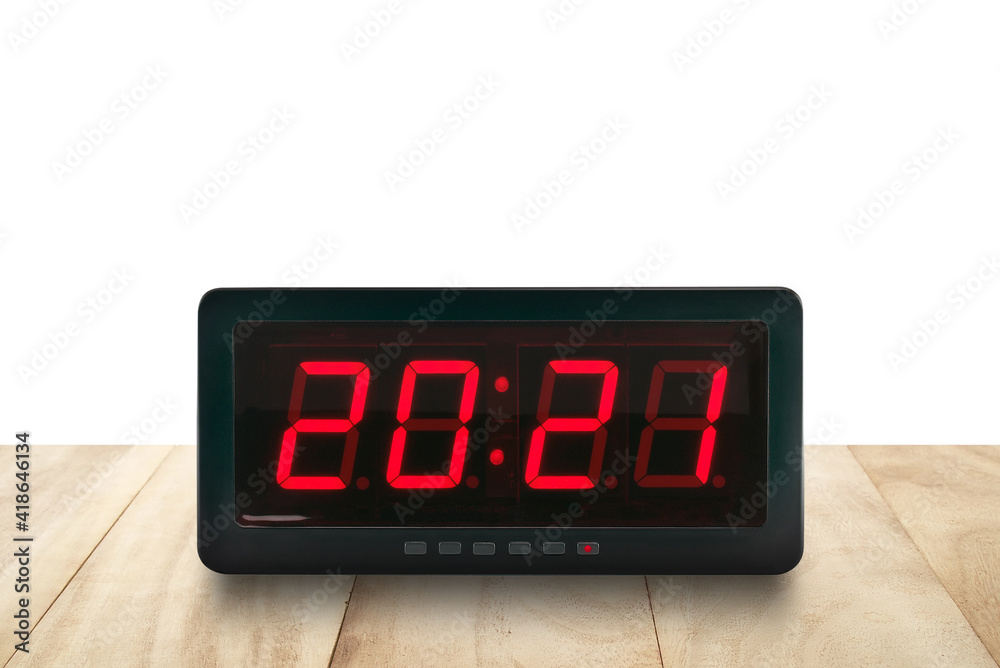 numbers 2021 on digital alarm clock face on wooden table isolated on white background