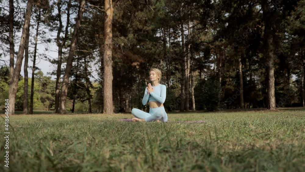 A yoga practitioner does exercises during the day in an outdoor park. A yoga practitioner does exercises during the day in an outdoor park.