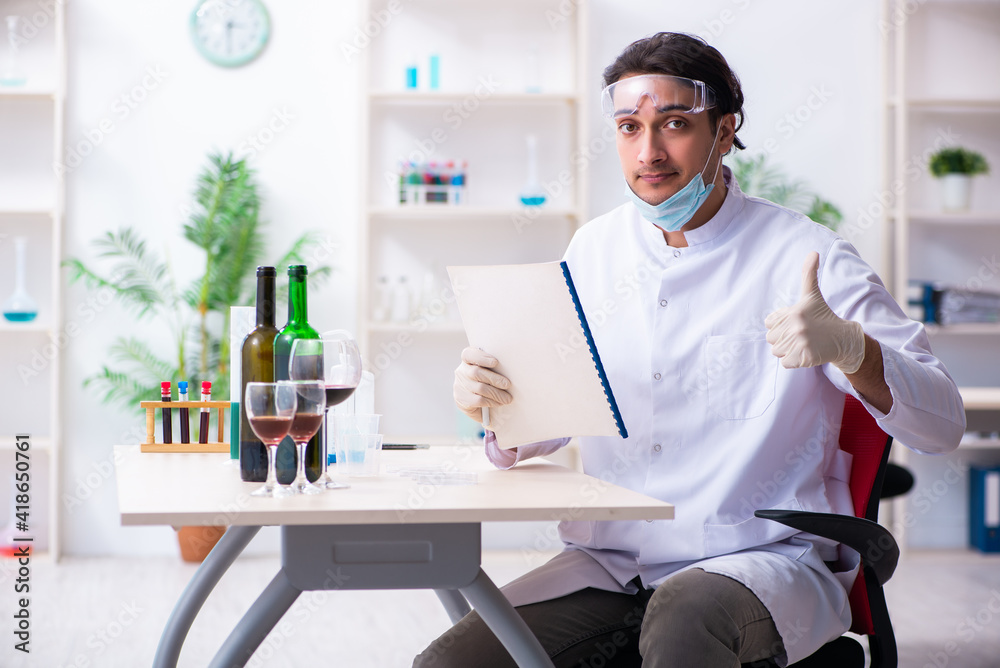 Male chemist examining wine samples at lab Male chemist examining wine samples at lab