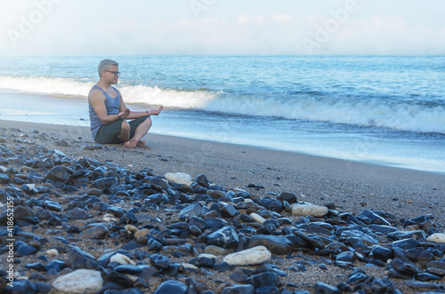Man meditating on the beach © Jeanny