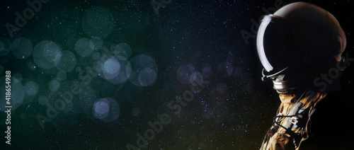 Fototapeta Naklejka Na Ścianę i Meble -  Concept of an astronaut looking up into the stars with bokeh. Sci-fi space exploration collage, copy space. Elements of this image furnished by NASA.