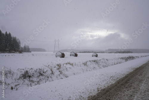 Snowing in a field and road in the winter