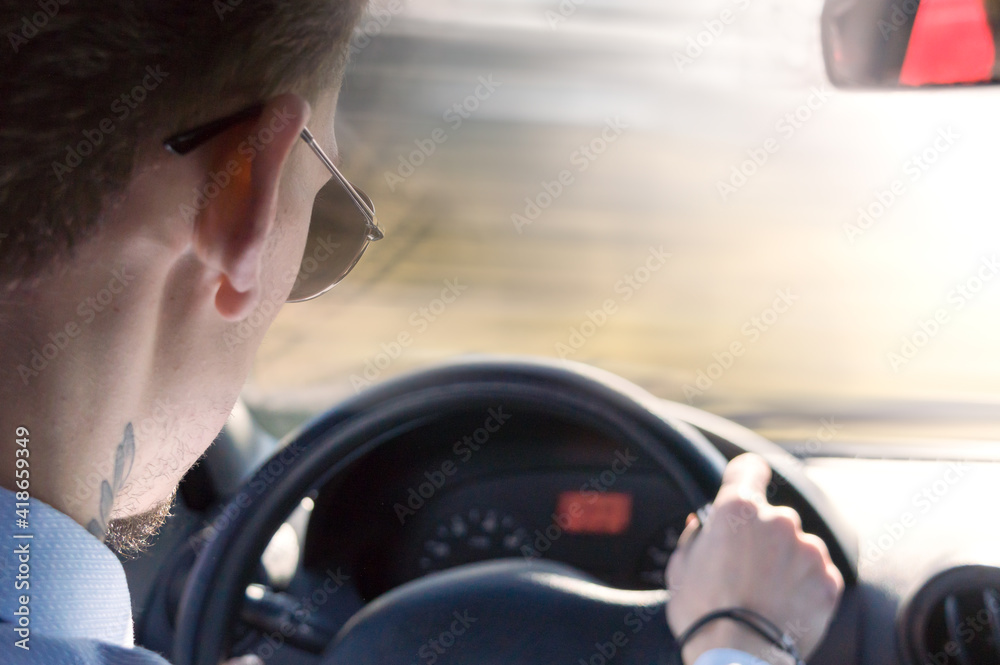 Shot of young businessman driving car, rear view. Shot of young businessman driving car, rear view.