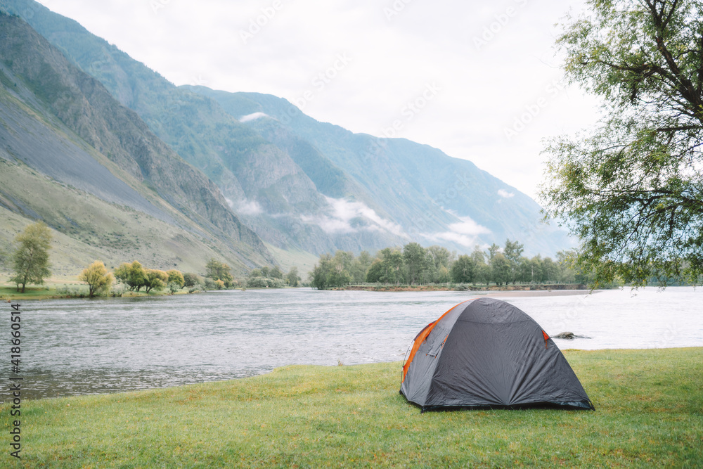 hiking tent on the beach of mountain river