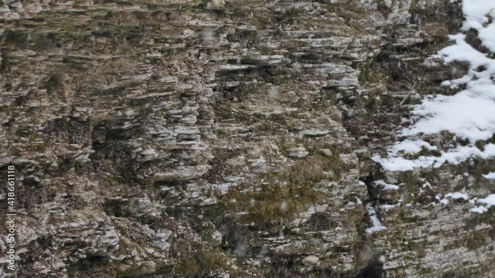 Snow is falling on the rocks. Snowflakes are slowly falling. Winter beauty Snow is falling on the rocks. Snowflakes are slowly falling. Winter beauty