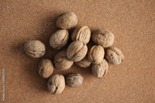 Walnuts with and without shells. Fresh walnuts on cork board