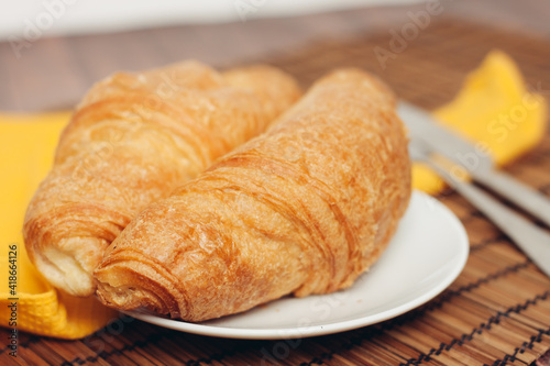 croissants saucer on the table fork with a knife fresh pastries dessert morning