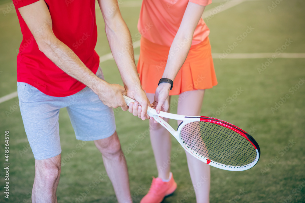 Close up picture of man and woman holding a racket