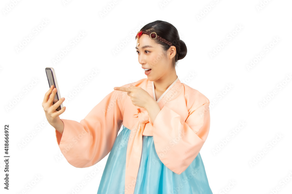 Beautiful Asian women wearing Korean national costume Hanbok holding a smartphone white background Beautiful Asian women wearing Korean national costume Hanbok holding a smartphone white background