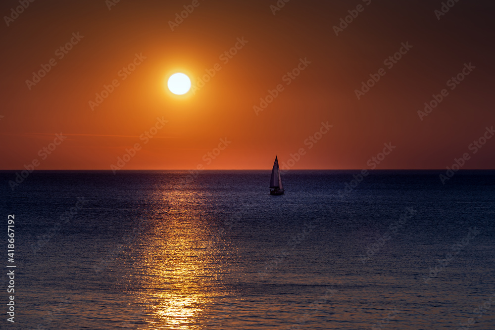 The sailboat sails towards sunset