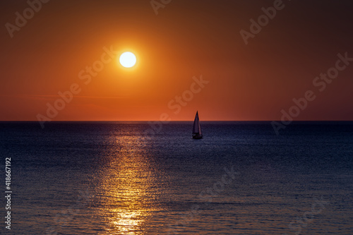 The sailboat sails towards sunset