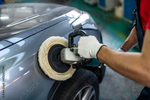 Фотография Male hands with polishing machine on surface of car