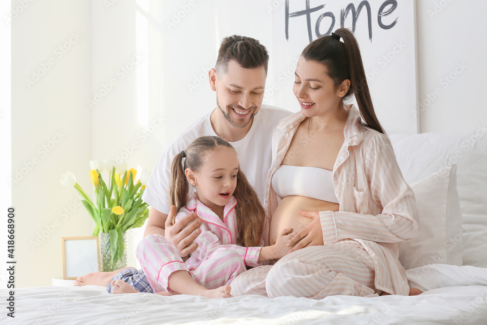 Young pregnant woman with her family at home