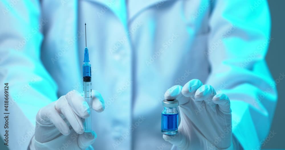 Close up video hands of doctor or researcher with vaccine and syringe. Covid-19 coronavirus vaccination Close up video hands of doctor or researcher with vaccine and syringe. Covid-19 coronavirus vaccination