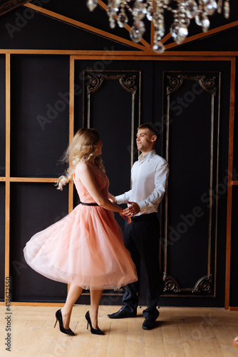 Young man and woman dancing in the home interior