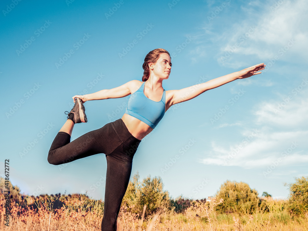 Young woman in sportswear doing pilates in the countryside Young woman in sportswear doing pilates in the countryside