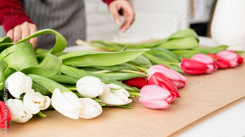 Fototapeta Naklejka Na Ścianę i Meble -  Woman florist making a bouquet of fresh colorful tulips