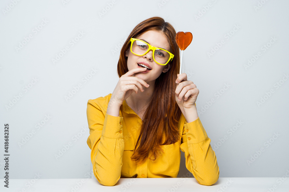 cheerful woman sitting at the table stick with heart yellow glasses cheerful woman sitting at the table stick with heart yellow glasses