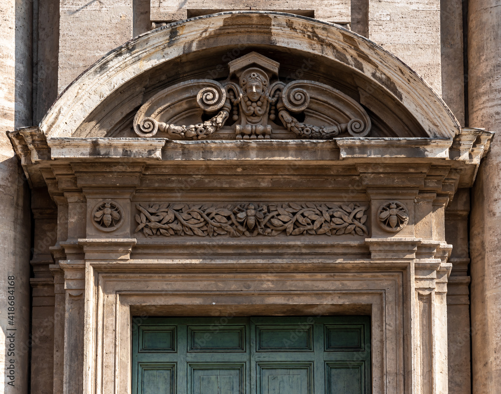 Close-up on decorative sculpture carved above marble door of old building in Rome