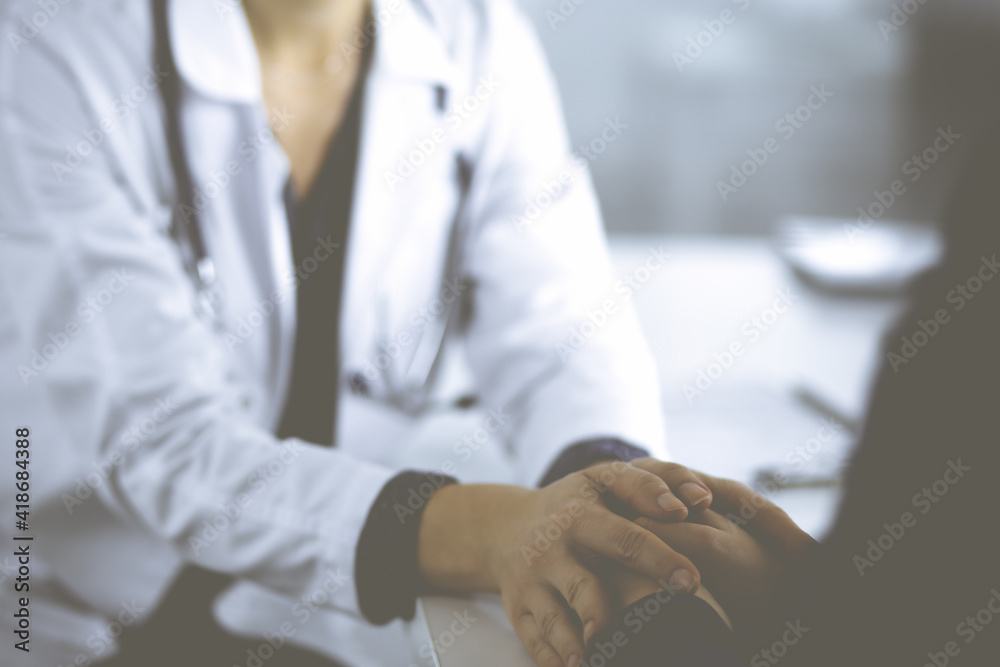 Obraz premium Unknown woman-doctor is reassuring her female patient, close-up. Physician is consulting and giving some advices to a woman. Concepts of medical ethics and trust. Empathy in medicine