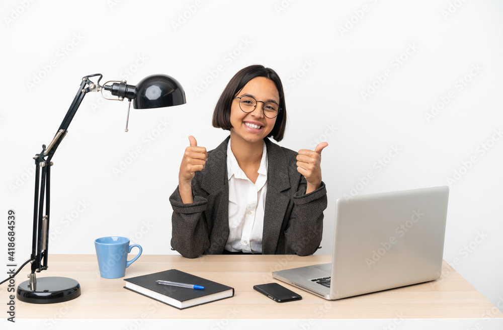 Young business mixed race woman working at office giving a thumbs up gesture Young business mixed race woman working at office giving a thumbs up gesture