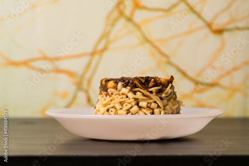 Famous traditional Arabic, Egyptian dish - Koshari. National Kushari in a white plate on dark wooden background photo