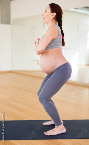 Pregnant woman is engaged in yoga. Utkatasana or Chair Pose