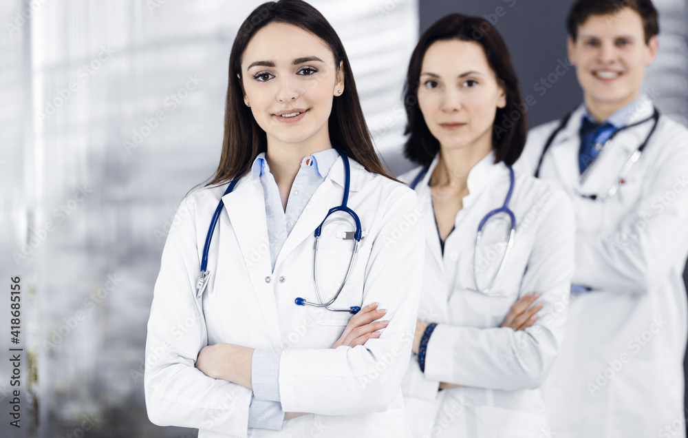 Group of young professional doctors is standing as a team with arms crossed in a hospital office and is ready to help patients. Medical help, insurance in health care, best disease treatment and Group of young professional doctors is standing as a team with arms crossed in a hospital office and is ready to help patients. Medical help, insurance in health care, best disease treatment and