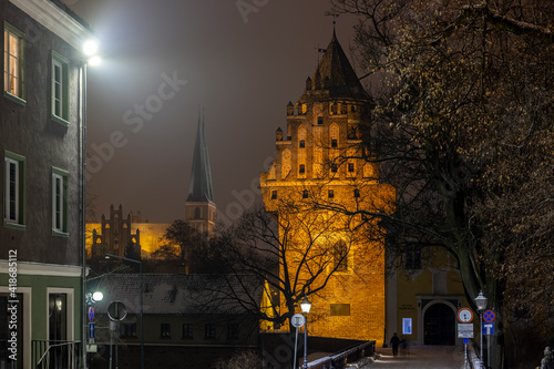 Fototapeta Naklejka Na Ścianę i Meble -  Olsztyn castle at night - the Castle of the Warmian Chapter in Olsztyn. Museum of Warmia and Mazury and the garrison church of Our Lady Queen of Poland in Olsztyn