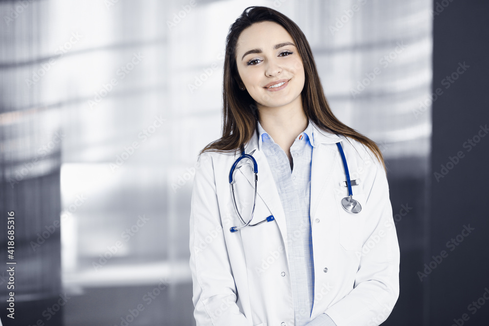 Professional young woman-doctor is looking at camera with a smile. Therapist at work in a clinic's office. Medicine concept Professional young woman-doctor is looking at camera with a smile. Therapist at work in a clinic's office. Medicine concept