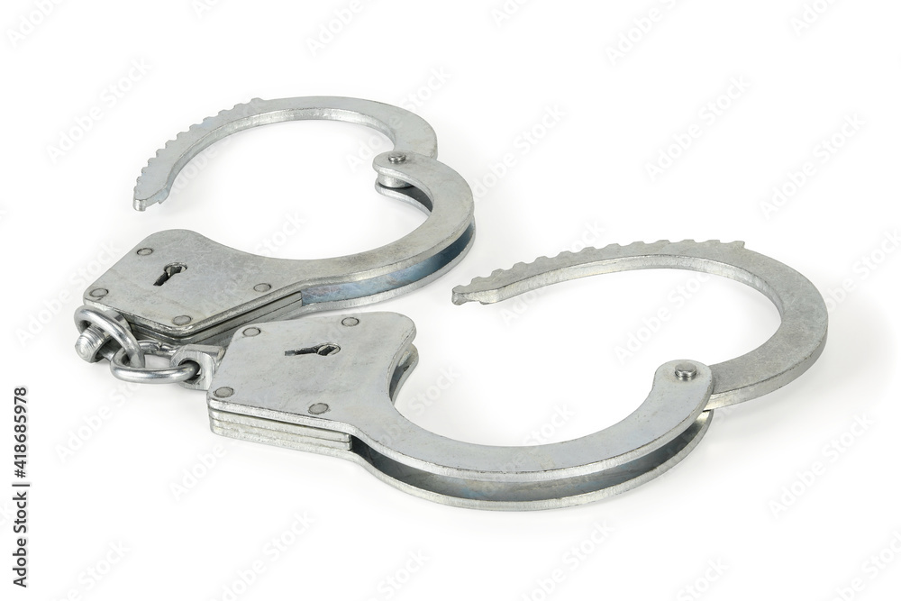 Police handcuffs isolated on white background with light shadows. Pair of real full open metal handcuff macro close-up high resolution, full depth of field. Police handcuffs isolated on white background with light shadows. Pair of real full open metal handcuff macro close-up high resolution, full depth of field.