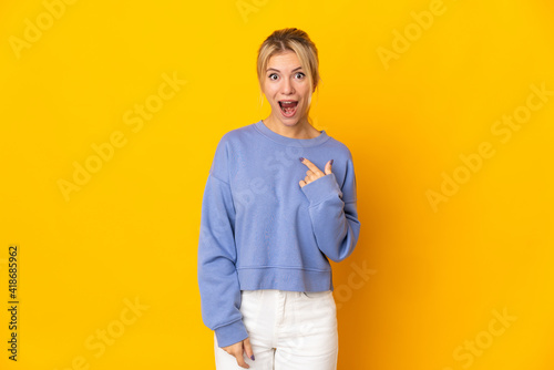 Young Russian woman isolated on yellow background with surprise facial expression