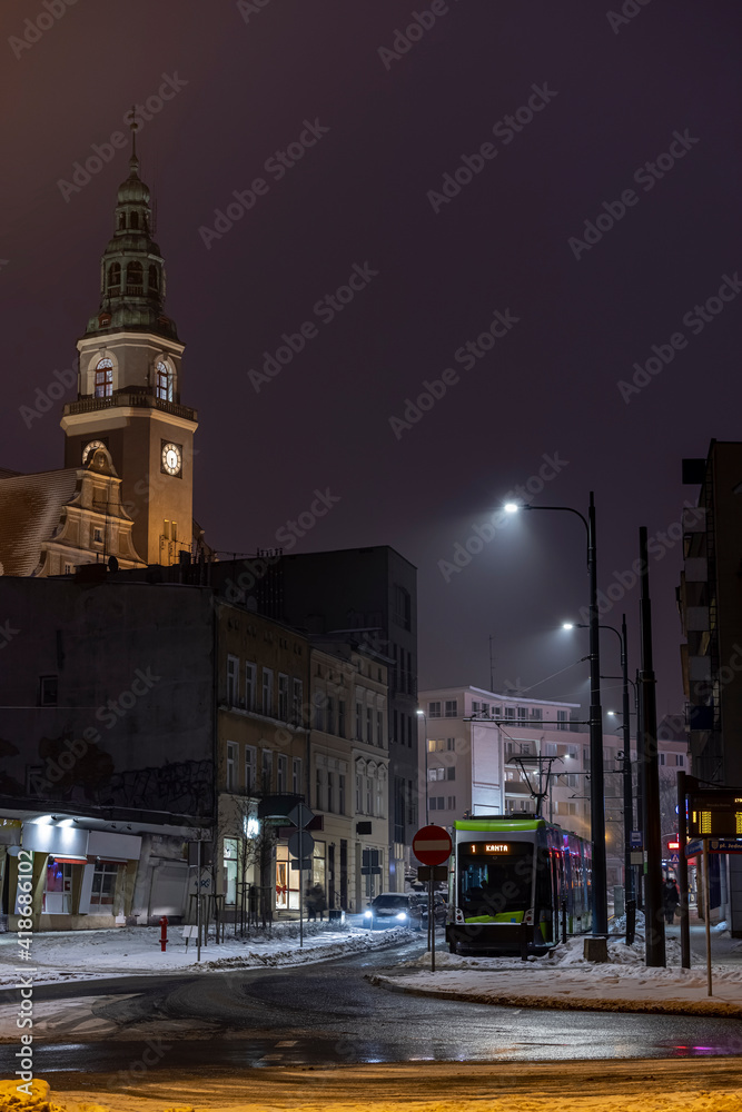 The center of Olsztyn - the town hall tower and a tram - in winter in the evening time